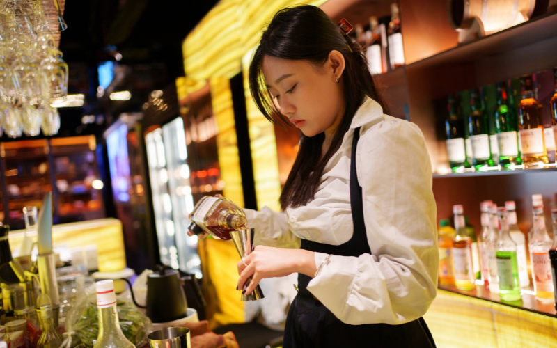 mixologist preparing a cocktail at a bar